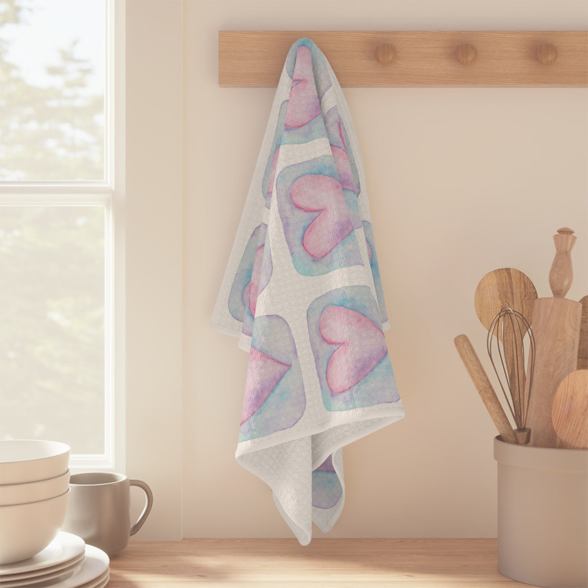 A white kitchen tea towel with a repeating pattern of pink hearts