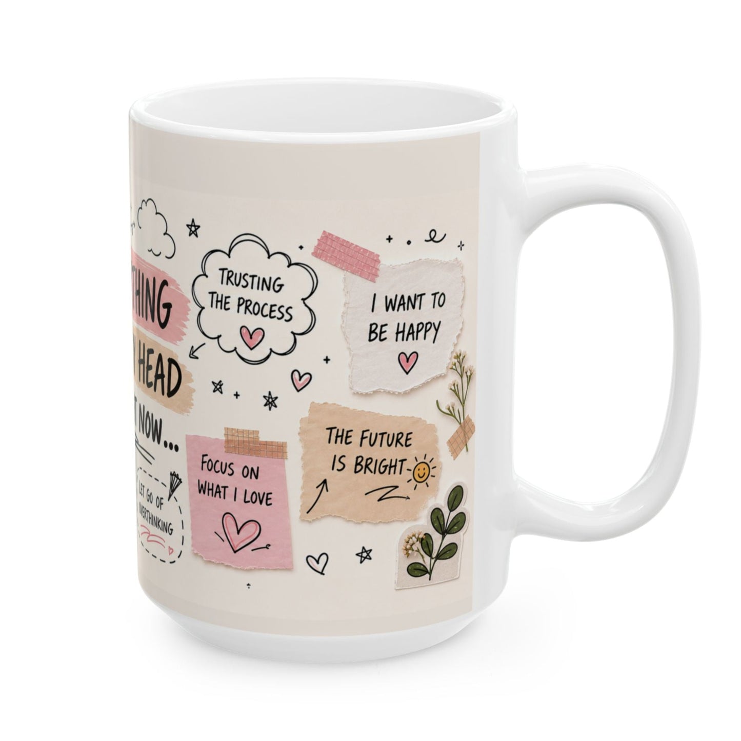 A white ceramic coffee mug with a pastel pink and beige graphic print featuring motivational quotes, hearts, and doodles on a clean white background.