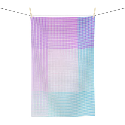 A rectangular kitchen towel with a pastel grid pattern hangs from two wooden clothespins on a wire against a plain white background.