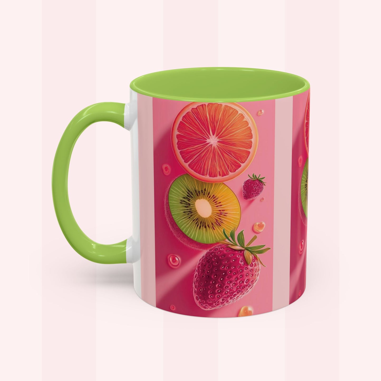 A ceramic mug with a bright green handle and interior, decorated with a pink and white striped design featuring illustrations of sliced grapefruit, kiwi, strawberries, and small citrus bubbles.