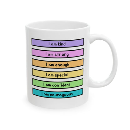 A white ceramic mug with a colorful graphic of six horizontal colored bars in purple, pink, orange, yellow, green, and blue, each printed with a positive phrase: 'I am kind', 'I am strong', 'I am enough', 'I am special', 'I am confident', and 'I am courageous'.